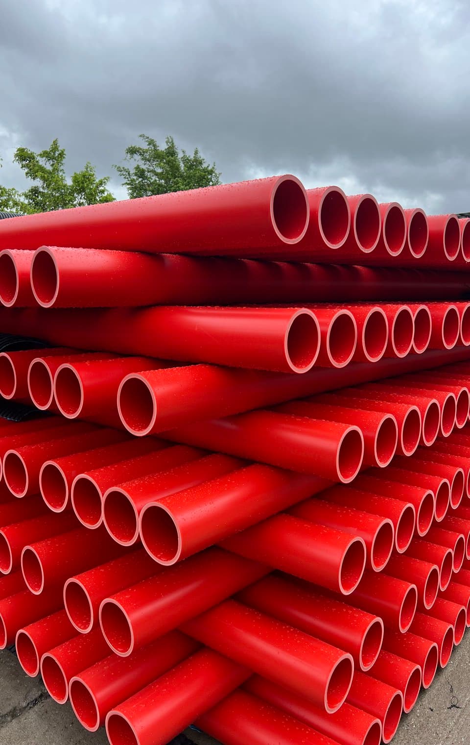 Red conduit stacked in the yard, the duct used to carry power and fibre underground