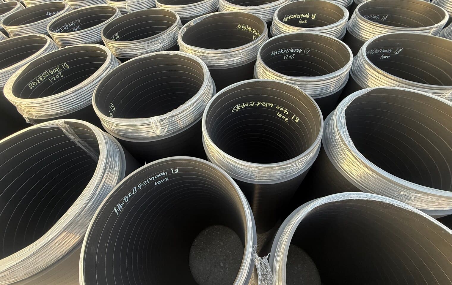 Heavy-wall pipe stacked end-on, the thick wall that abrasive slurry duty calls for clearly visible