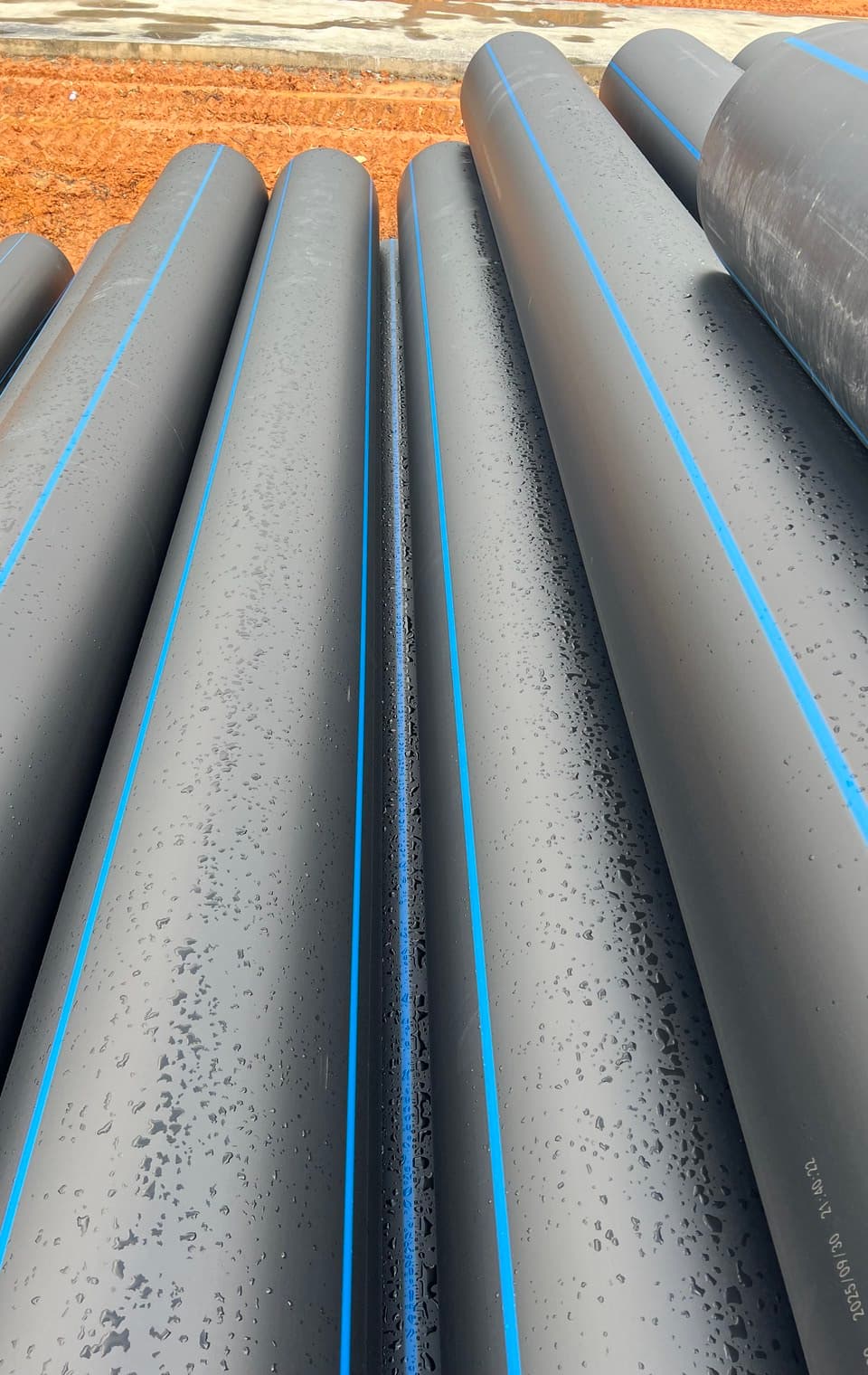 Blue-striped PE100 mains stock, the colour coding a water utility checks on delivery