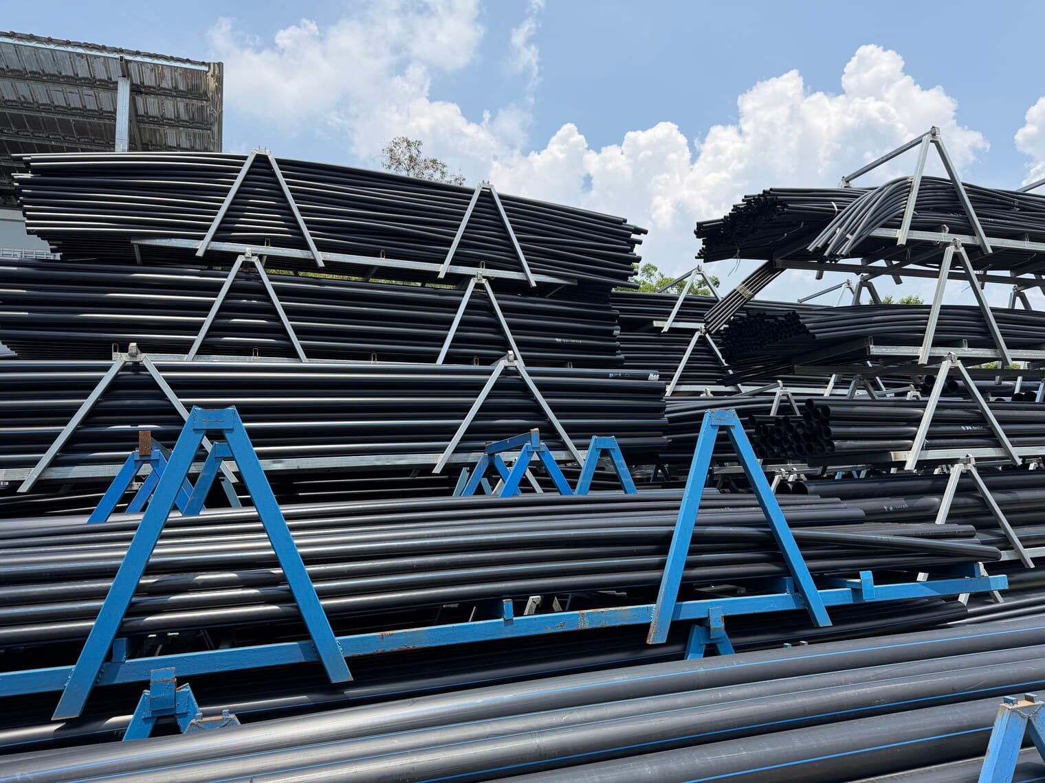 Bundles of blue-striped potable water pipe strapped and racked ready for despatch