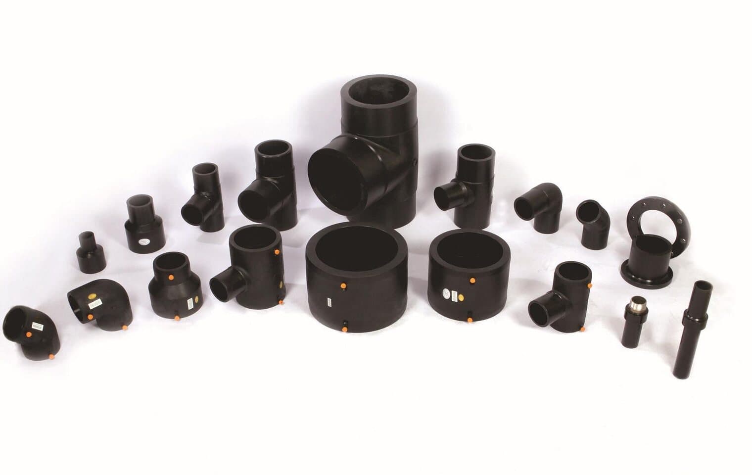 A full spread of butt fusion fittings laid out from the smallest coupler upward