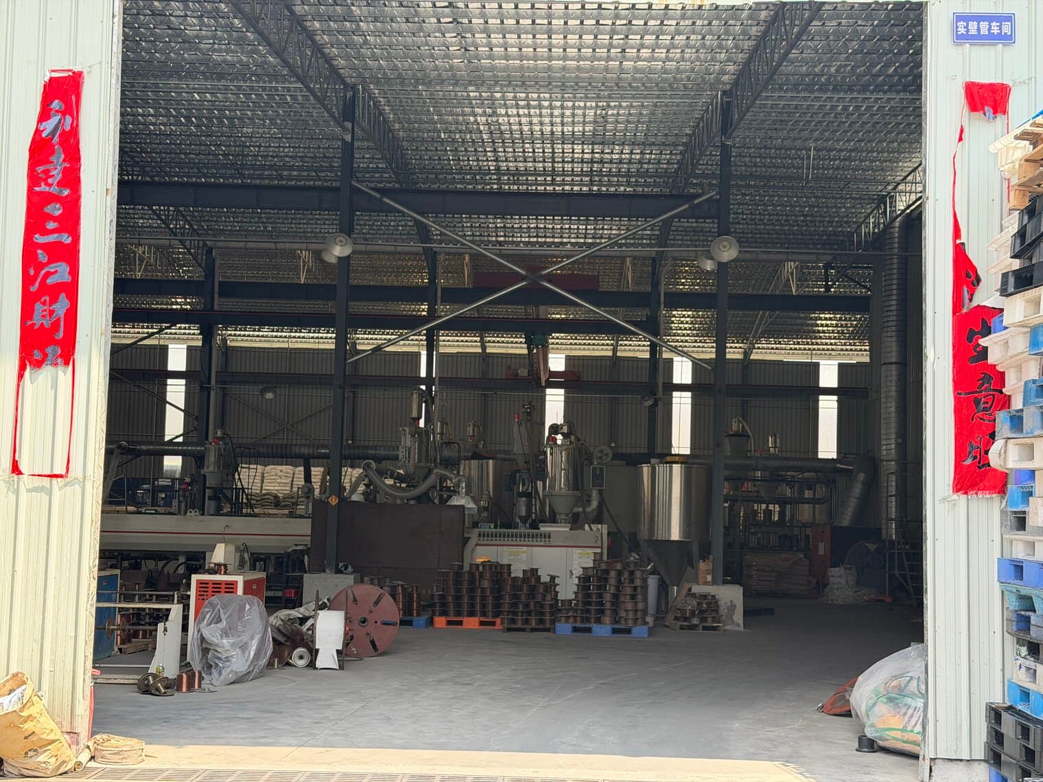 Inside the warehouse, with coiled pipe and bagged raw material held in stock