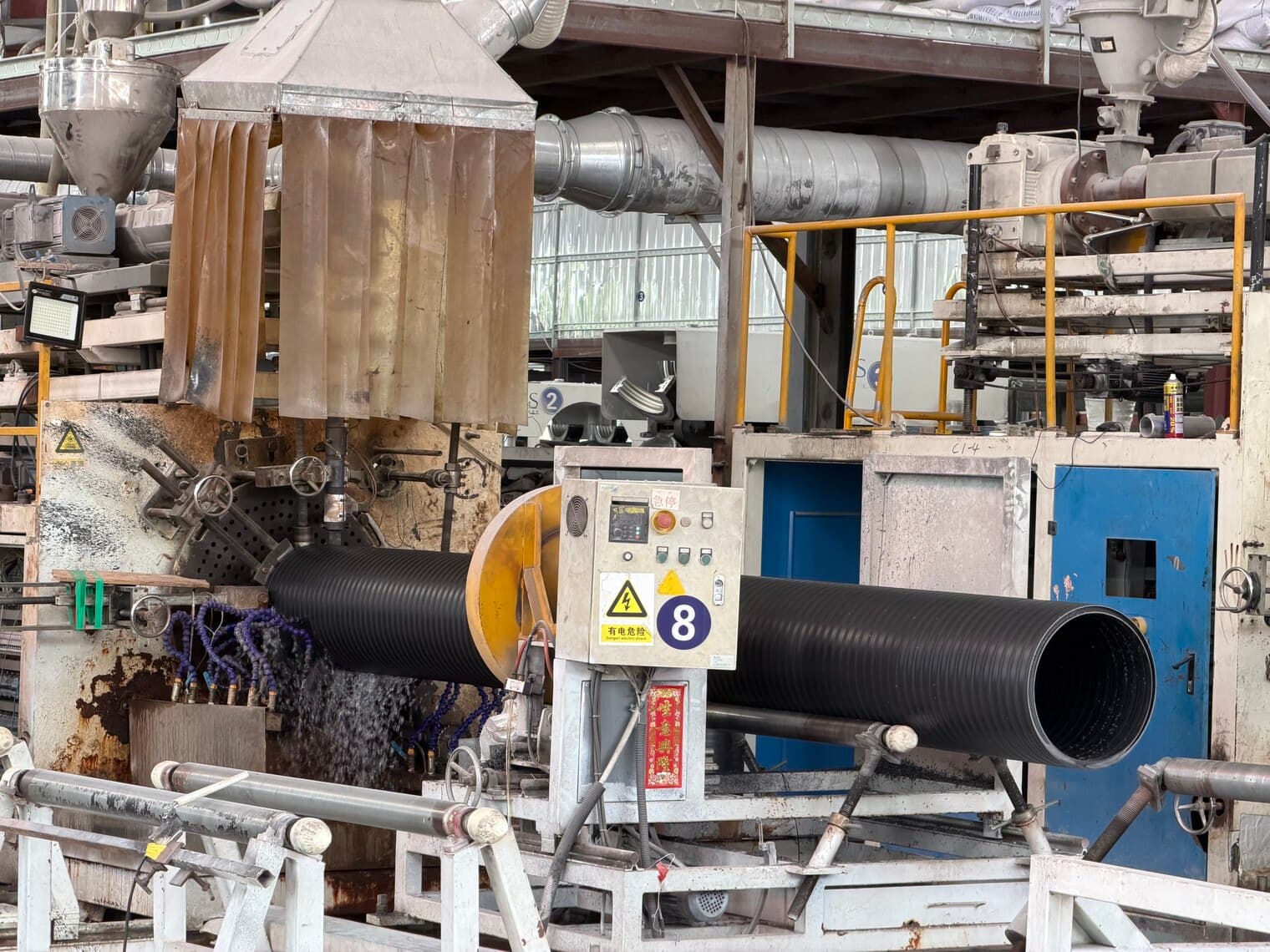 The corrugator forming double-wall pipe, a finished length emerging from the moulding blocks