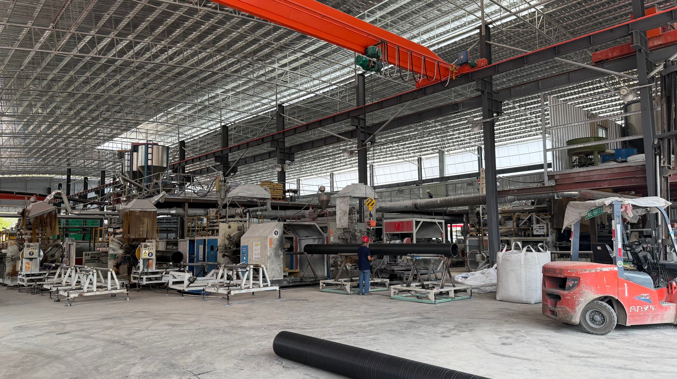 The main extrusion hall, lines running the length of the bay under an overhead gantry