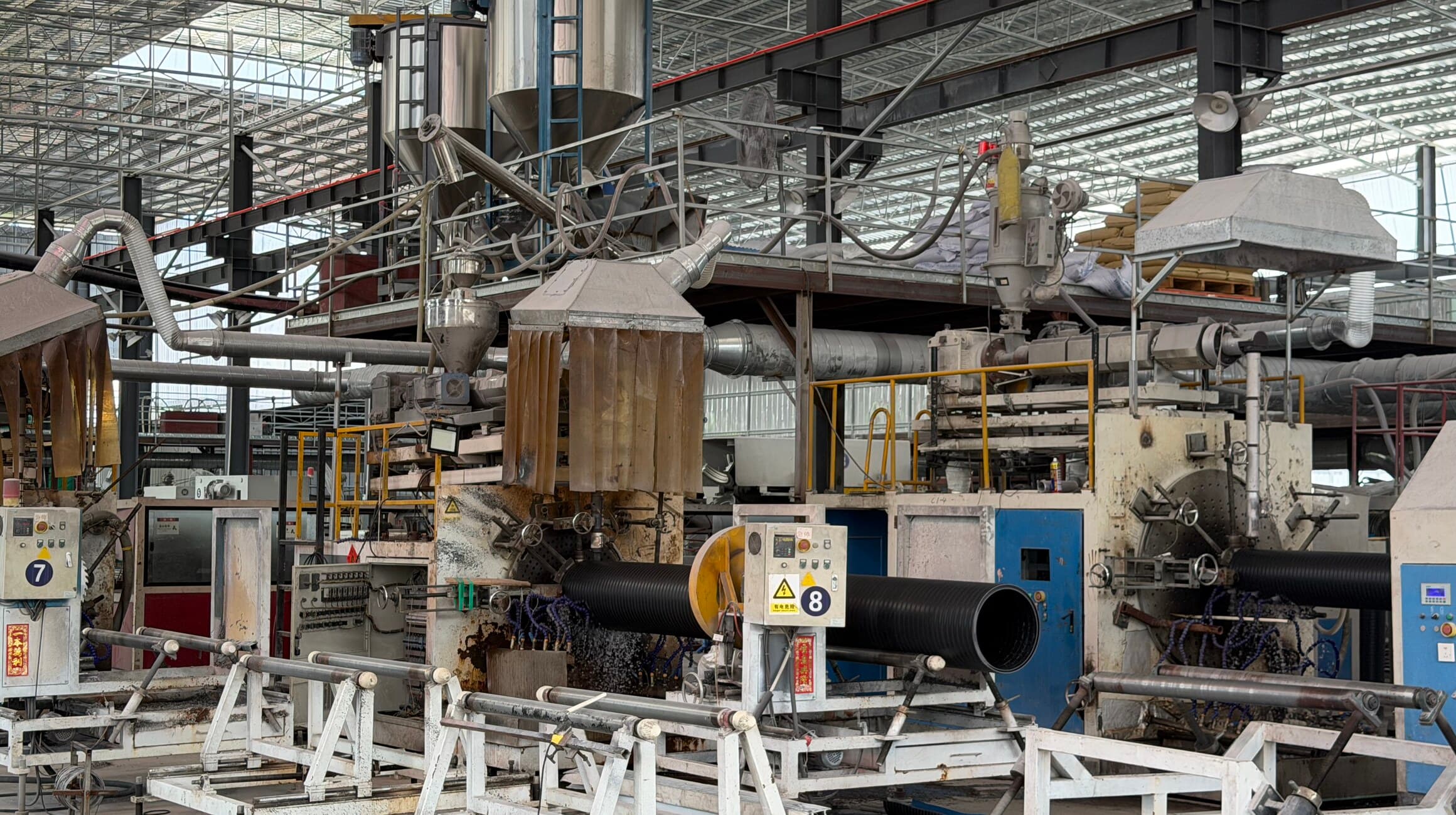 Looking down an extrusion line past the vacuum sizing and cooling tanks