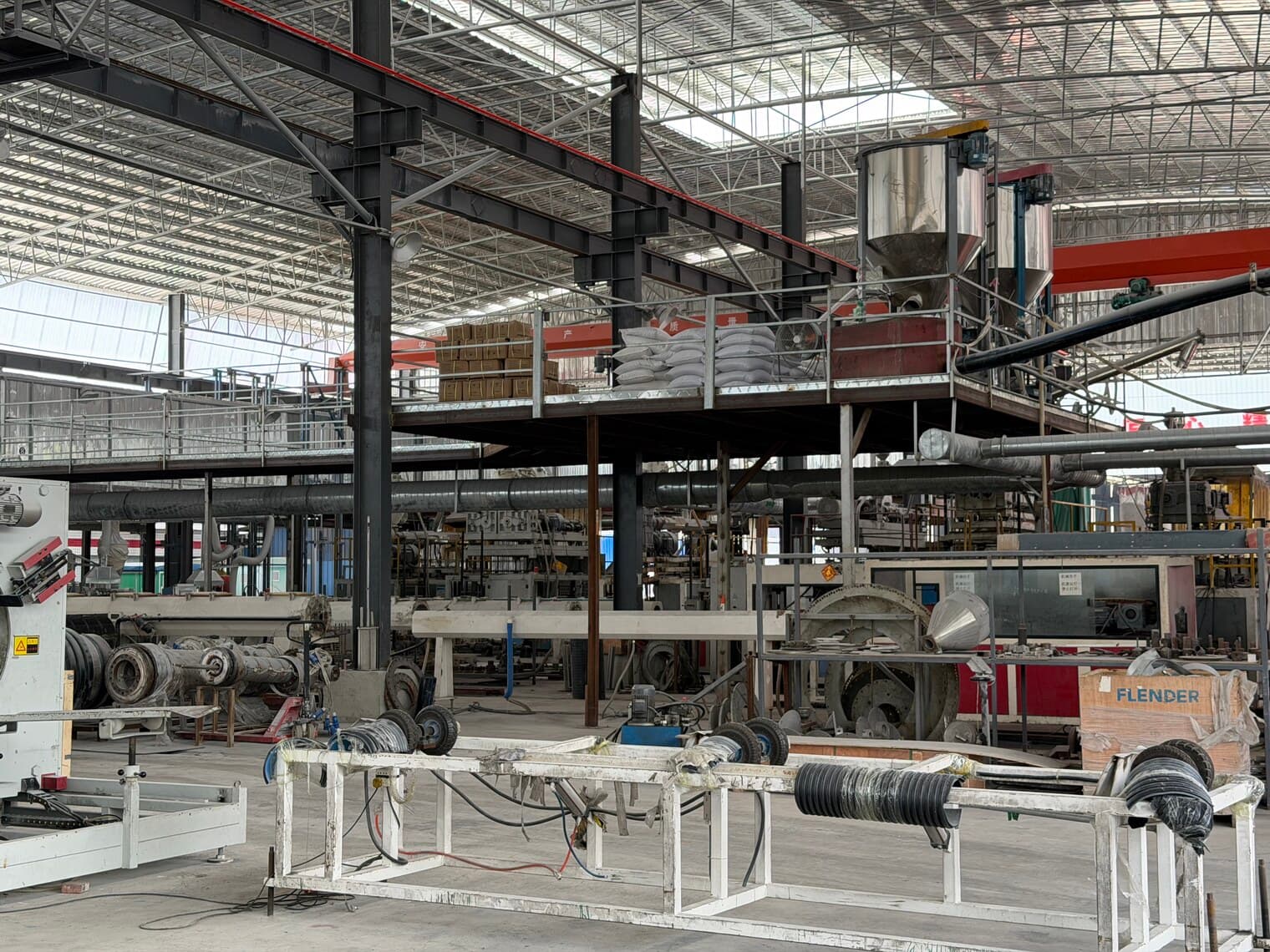 Inside the plant, with material feed hoppers above the extruder barrels
