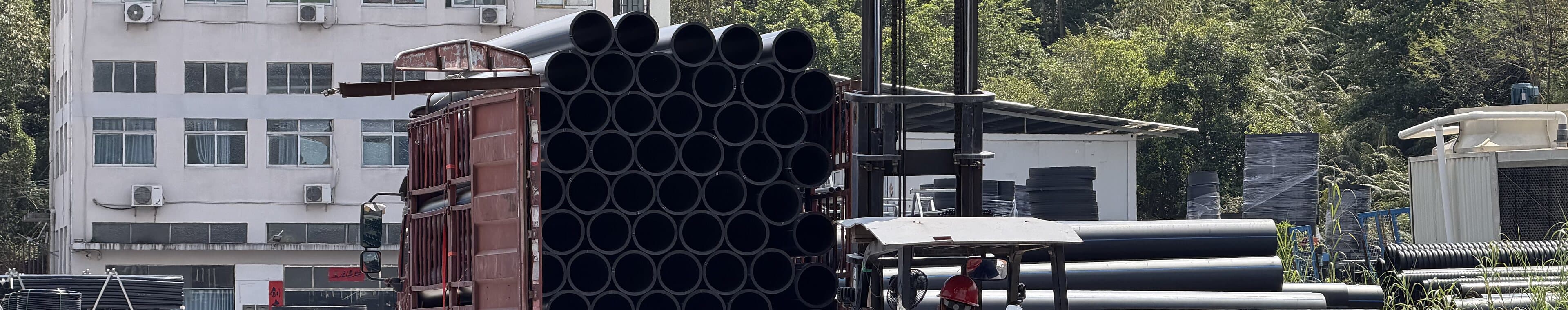 Pipe loaded onto a flatbed by forklift at the works gate