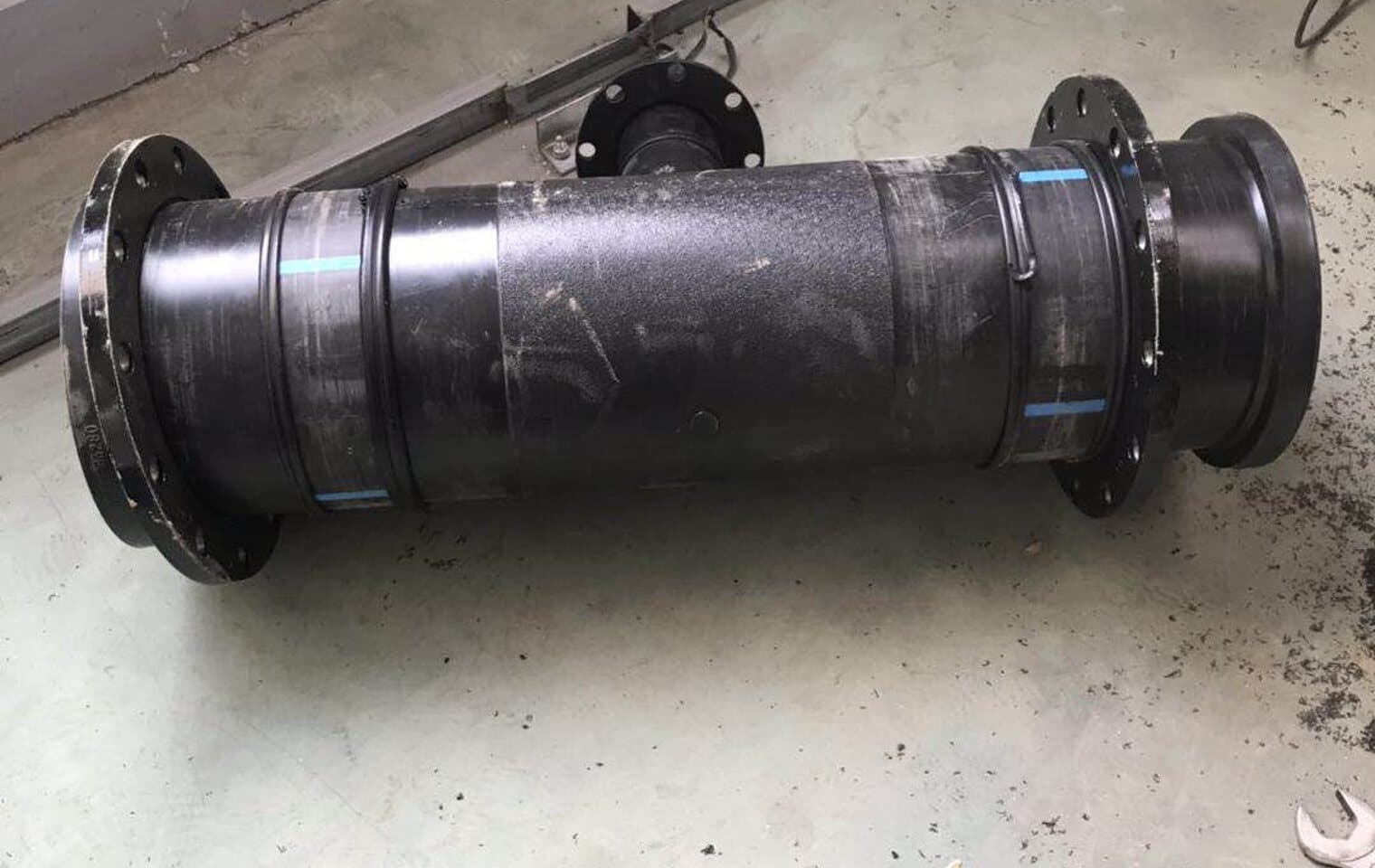 A flanged PE spool on the workshop floor, both ends drilled for a mine water line