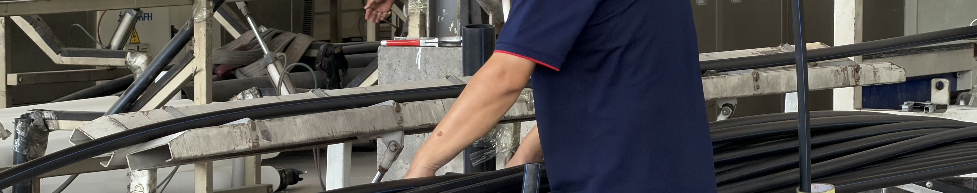 A production hand guiding a bundle of pipe off the line