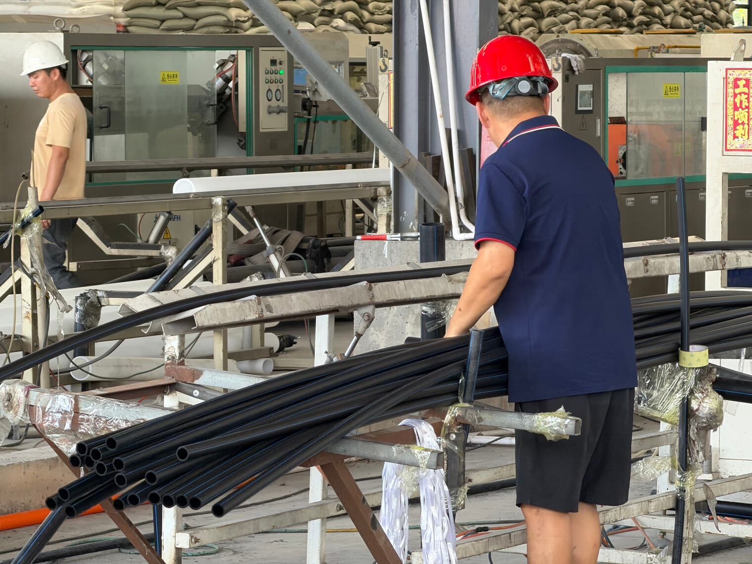 An operator guiding small-diameter pipe onto the coiler