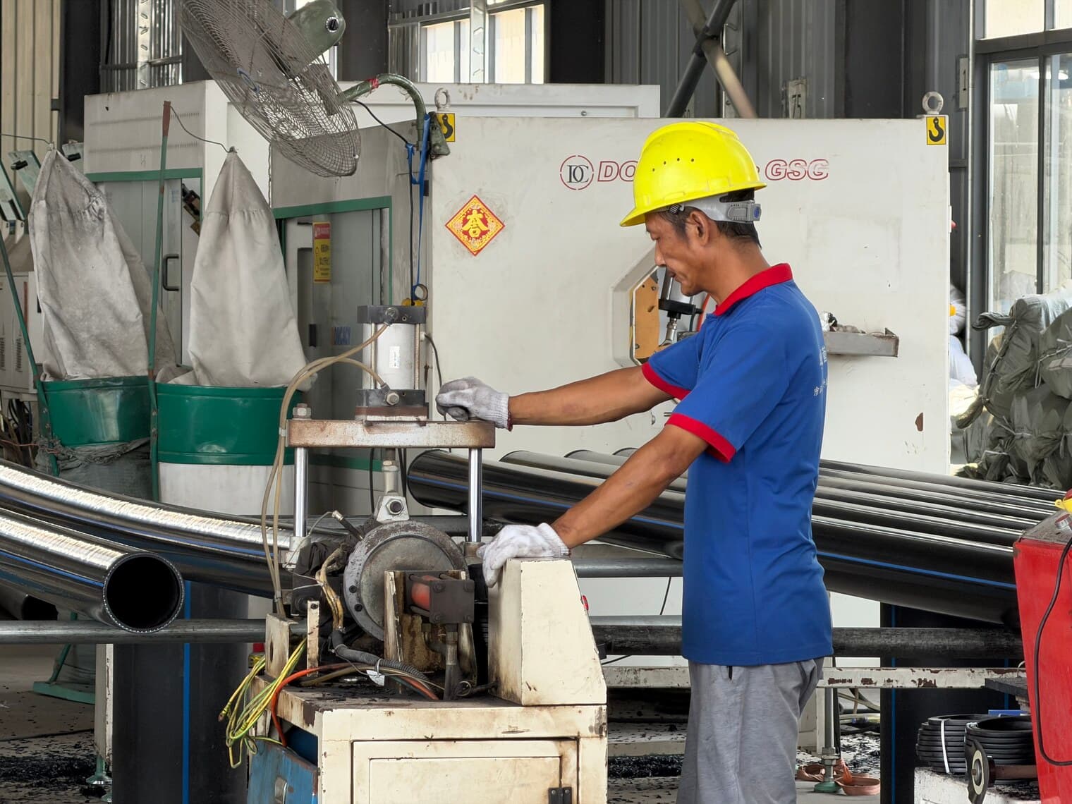 An operator working the cut-off saw at the end of a line
