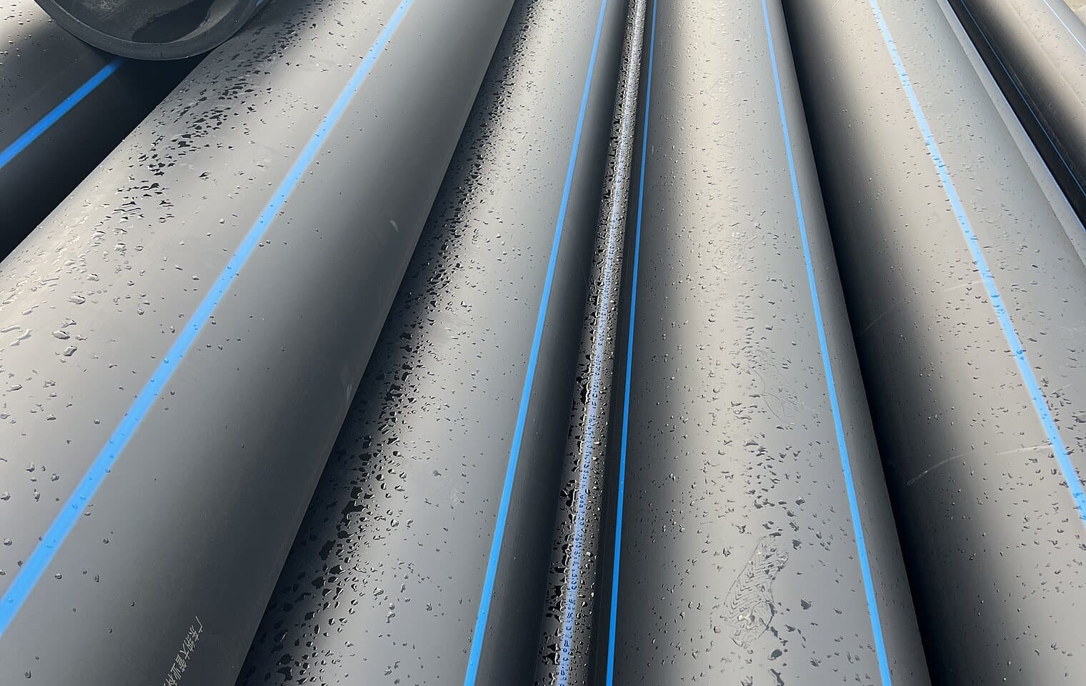 The printed legend and blue stripe running along a PE100 pipe barrel