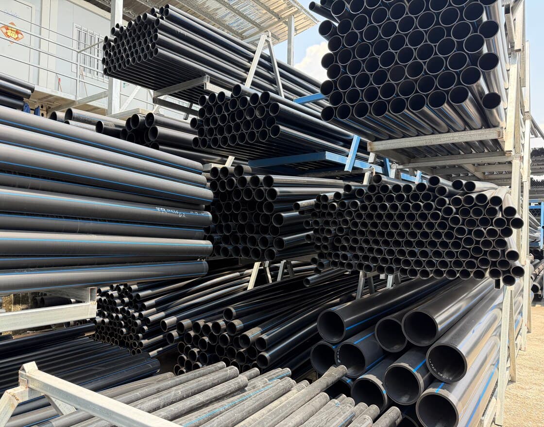 Black HDPE pipe in our stock yard, cut lengths racked by diameter with the ends facing out