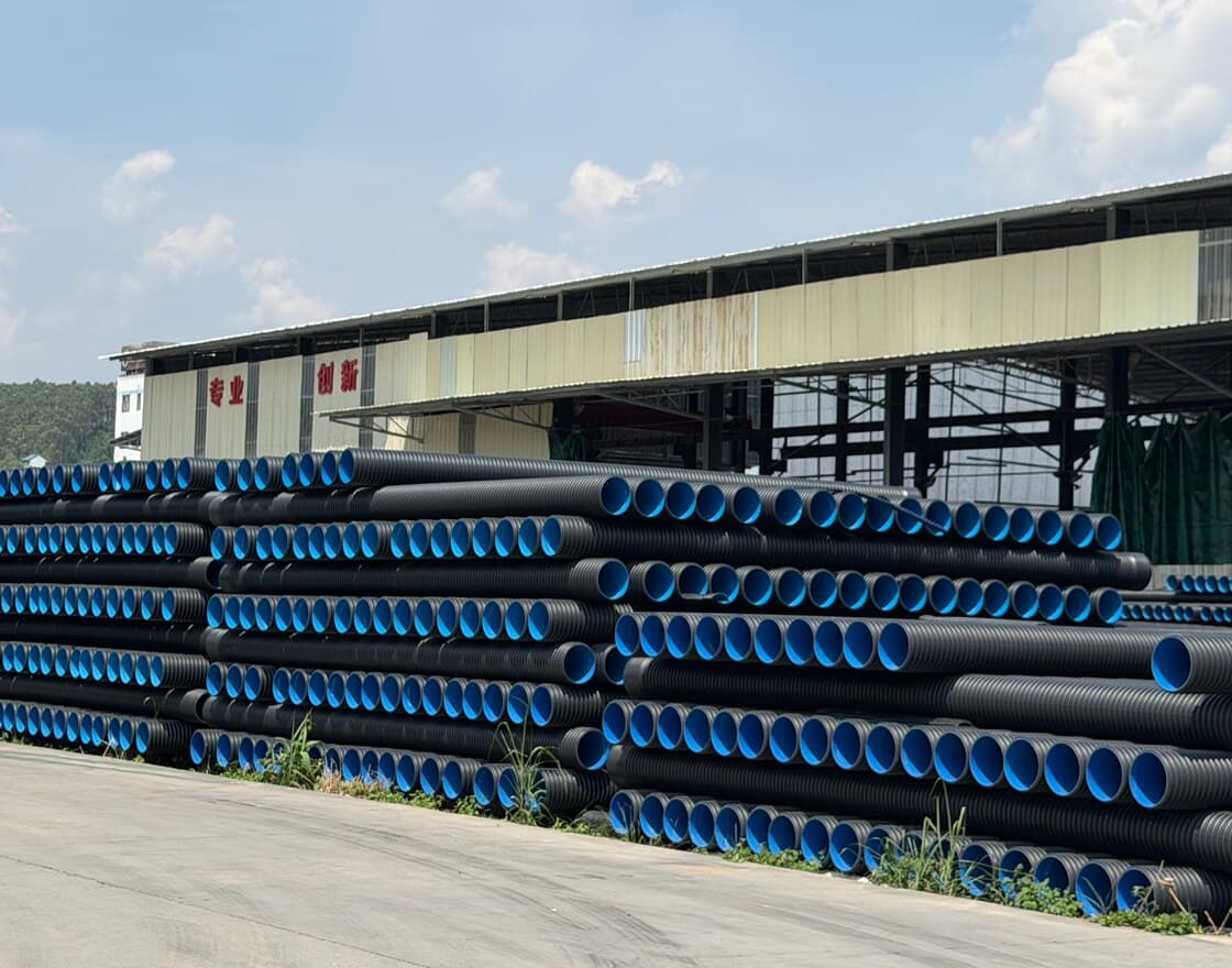 Our yard alongside the production hall, stacked with blue-lined double-wall corrugated pipe