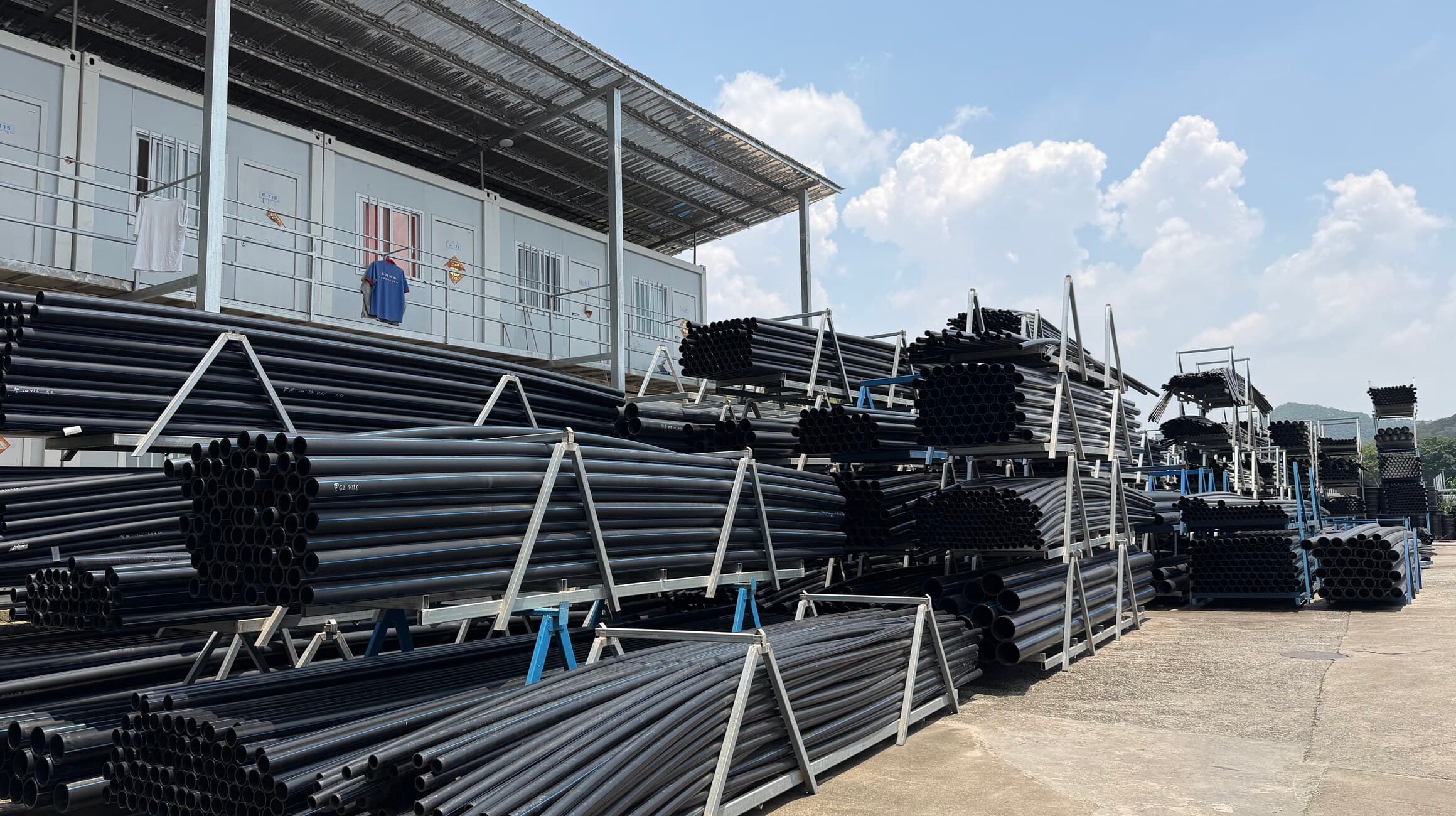 The yard outside our production hall, with black PE pipe racked on A-frames