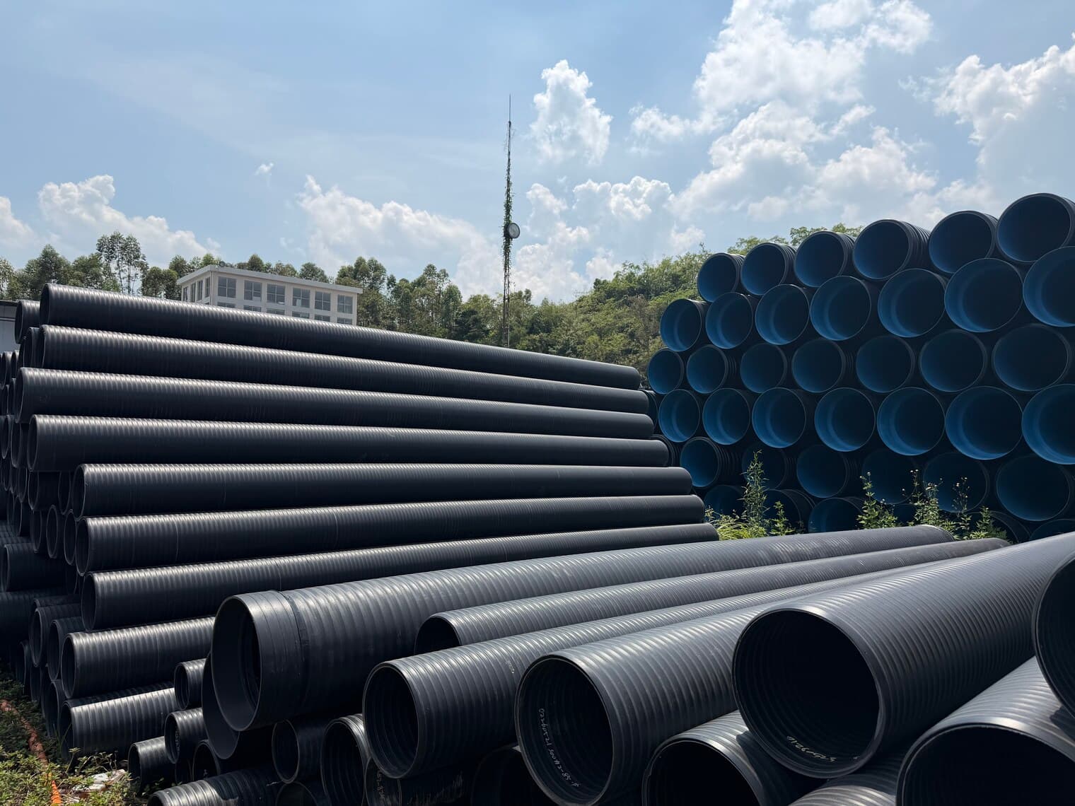 Corrugated sewer pipe held in stock along both sides of the yard road