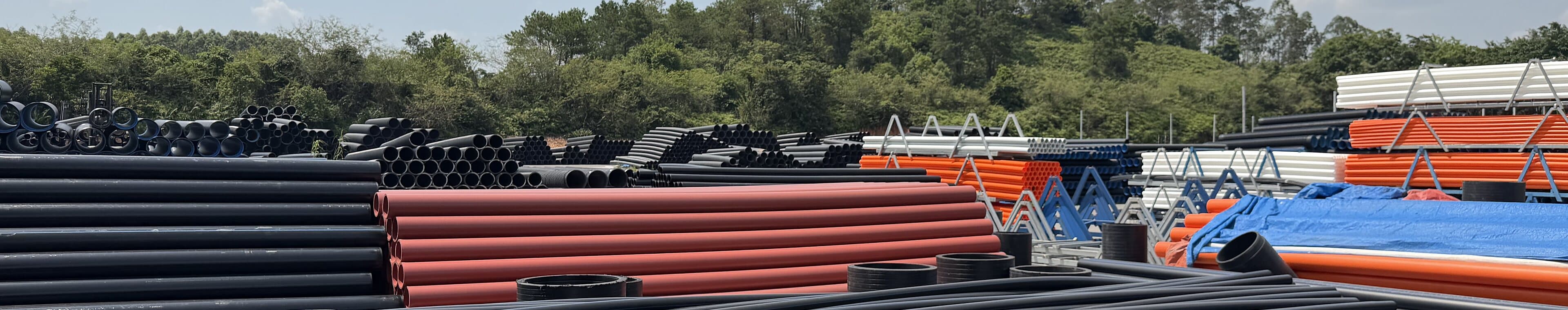 Finished pipe in several colours held in the yard between production runs