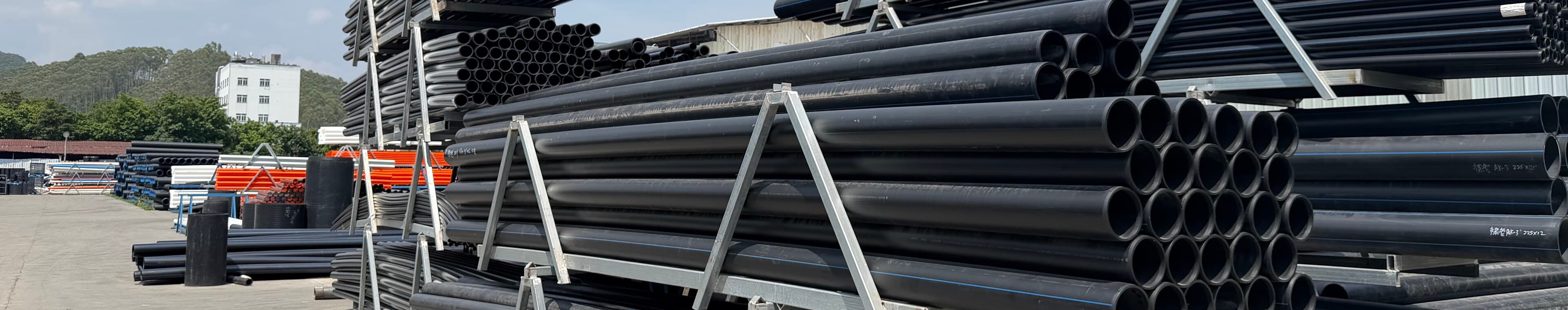 Bundles of black PE100 pipe racked in the stock yard, cut ends facing the camera