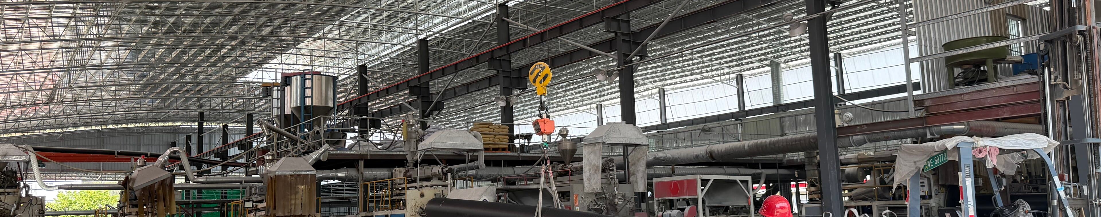 A wide view along the production hall with extrusion lines and overhead gantry