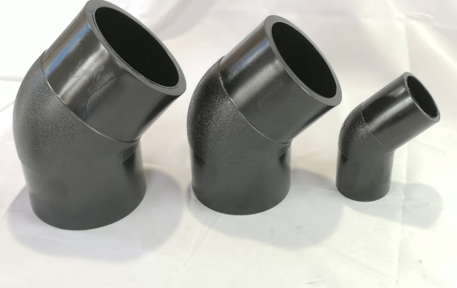 A graded set of 45 degree PE elbows laid out after fabrication