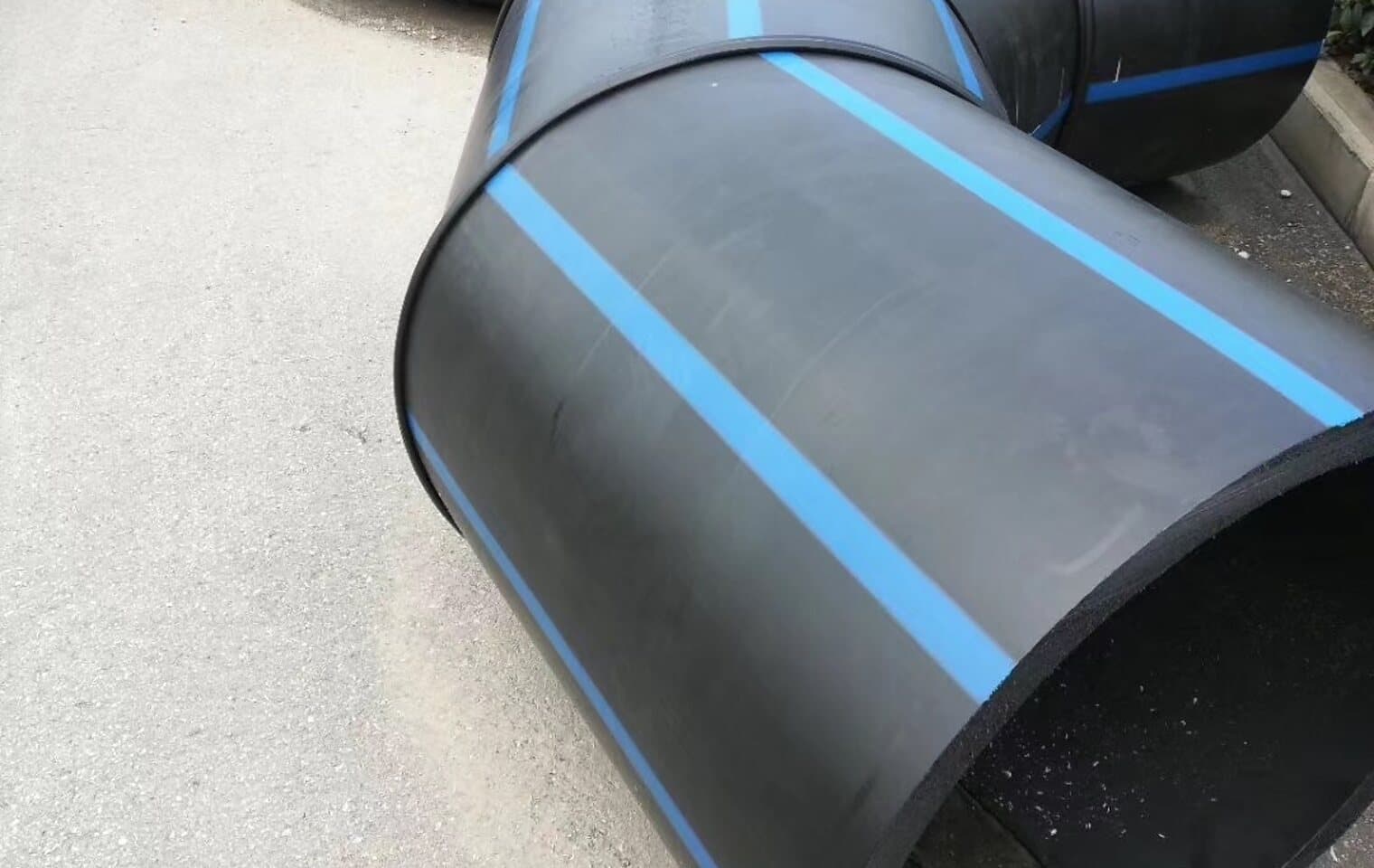 Segmented large-diameter elbows with the blue potable stripe, welded up and waiting in the yard